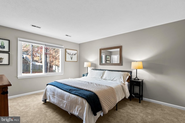 bedroom with a textured ceiling and light carpet