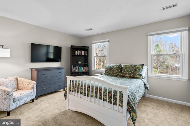 bedroom with light colored carpet and multiple windows