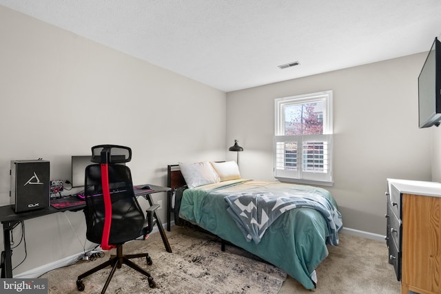 bedroom featuring light colored carpet and a textured ceiling