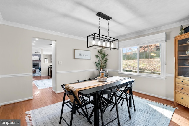 dining area featuring crown molding and light hardwood / wood-style flooring