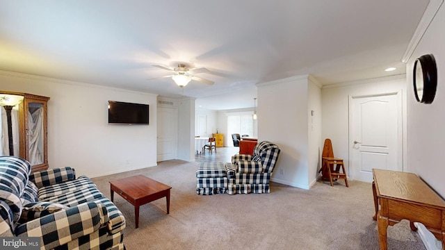 living room with ceiling fan, ornamental molding, and light carpet