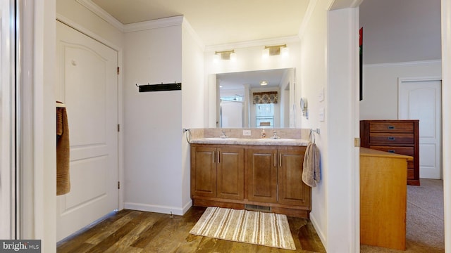 bathroom featuring hardwood / wood-style floors, vanity, and ornamental molding