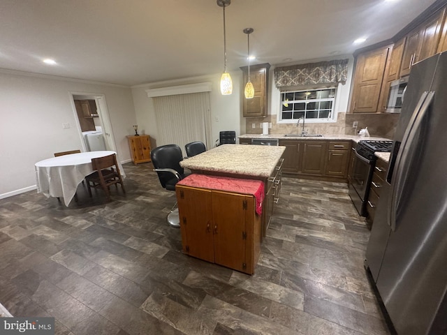 kitchen featuring sink, decorative backsplash, decorative light fixtures, a kitchen island, and stainless steel appliances