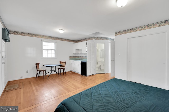 bedroom featuring light wood-type flooring and sink