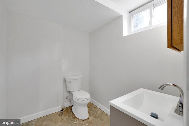 bathroom featuring vanity, concrete floors, and toilet