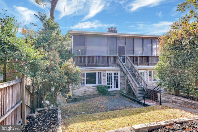 rear view of property with a sunroom and a patio area