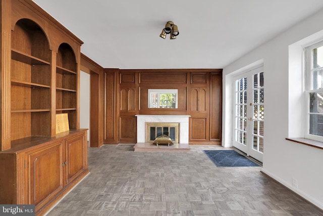 unfurnished living room with light parquet flooring, a premium fireplace, and plenty of natural light