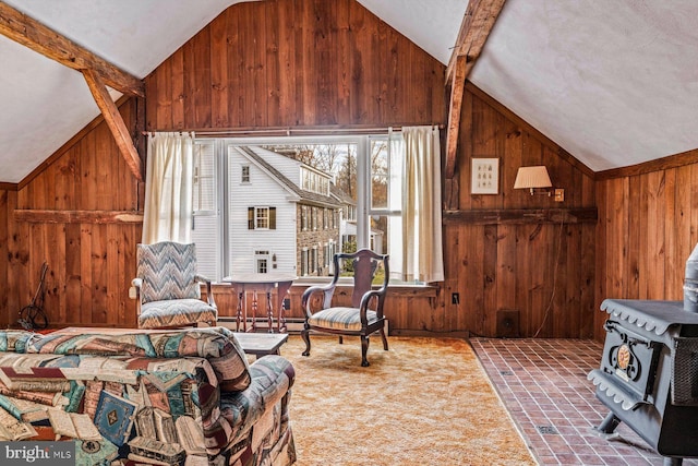 interior space with wood walls, vaulted ceiling with beams, and a wood stove