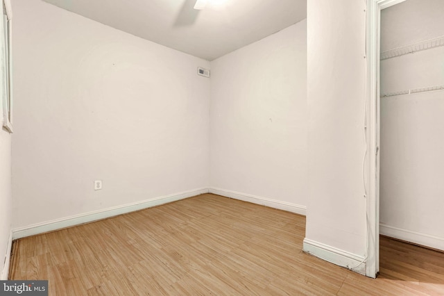 unfurnished bedroom featuring ceiling fan, a closet, and light wood-type flooring