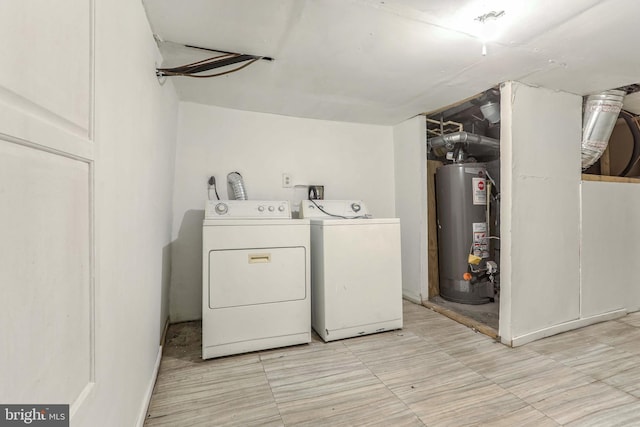 clothes washing area featuring washing machine and dryer and gas water heater