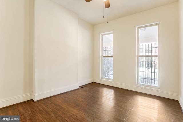 empty room with dark wood-type flooring and ceiling fan