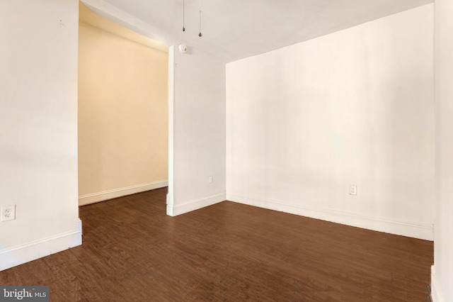 empty room with dark hardwood / wood-style flooring