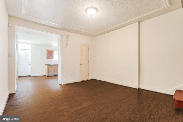 empty room featuring dark wood-type flooring and a textured ceiling