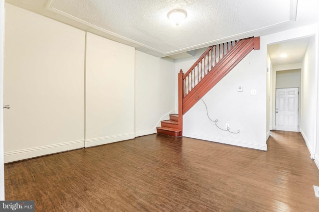 basement with hardwood / wood-style floors and a textured ceiling