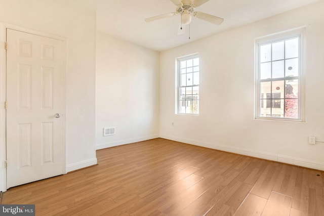 empty room with ceiling fan and light hardwood / wood-style flooring