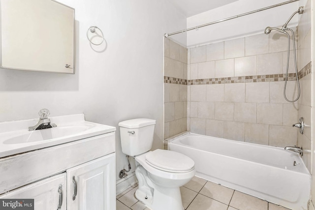 full bathroom featuring tile patterned flooring, tiled shower / bath combo, and toilet