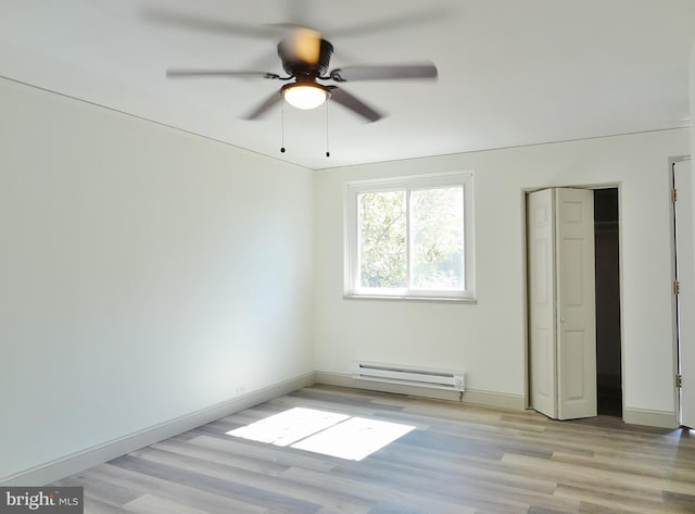 unfurnished bedroom featuring light hardwood / wood-style flooring, ceiling fan, and a baseboard heating unit