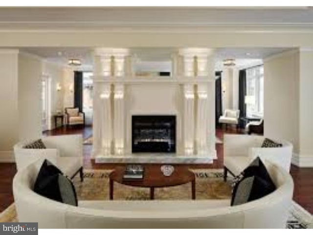 living room with crown molding, decorative columns, and dark hardwood / wood-style flooring