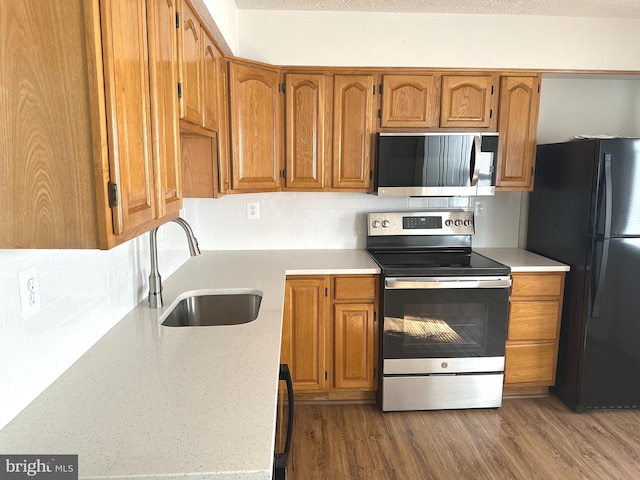 kitchen featuring decorative backsplash, appliances with stainless steel finishes, dark hardwood / wood-style flooring, and sink