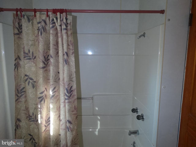 bathroom with shower / bath combo with shower curtain