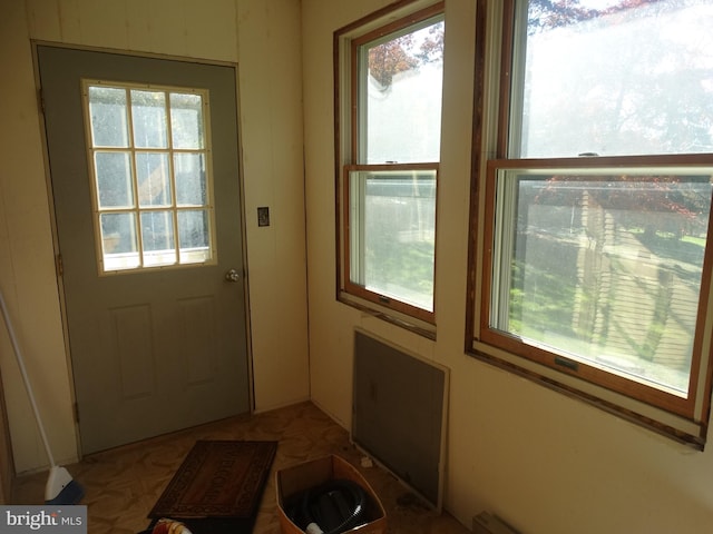 doorway with a baseboard radiator and a healthy amount of sunlight