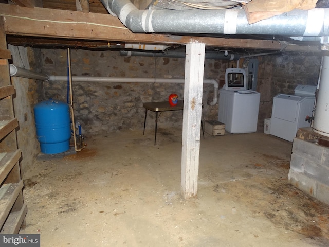 basement with electric panel, washer and clothes dryer, and gas water heater