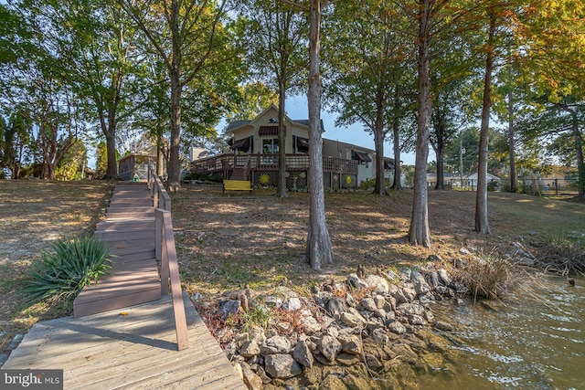 back of property featuring a deck with water view