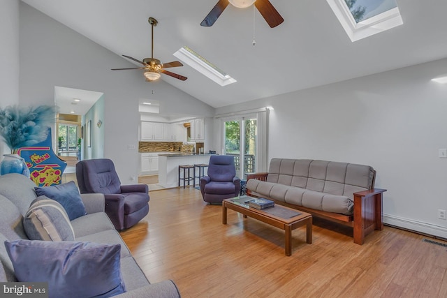 living room with a wealth of natural light, light hardwood / wood-style floors, and ceiling fan