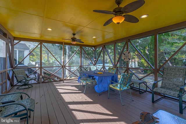 unfurnished sunroom featuring ceiling fan and a wealth of natural light