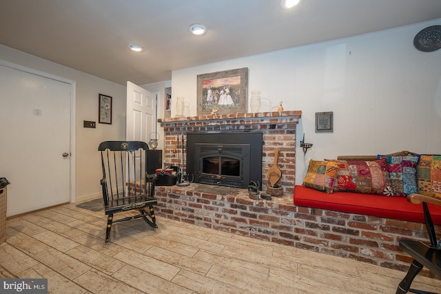 living room featuring wood-type flooring and a brick fireplace