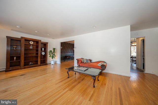 living area with light wood-type flooring and baseboard heating