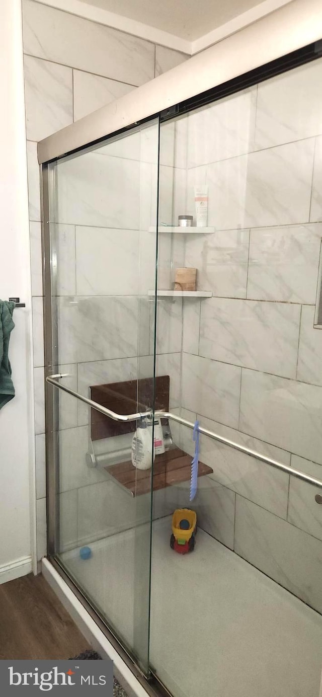 bathroom featuring a shower with door and hardwood / wood-style flooring