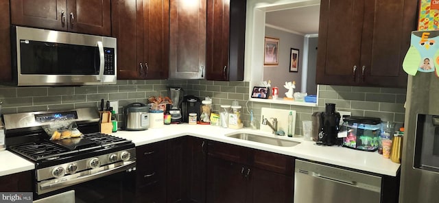 kitchen featuring crown molding, appliances with stainless steel finishes, sink, and decorative backsplash