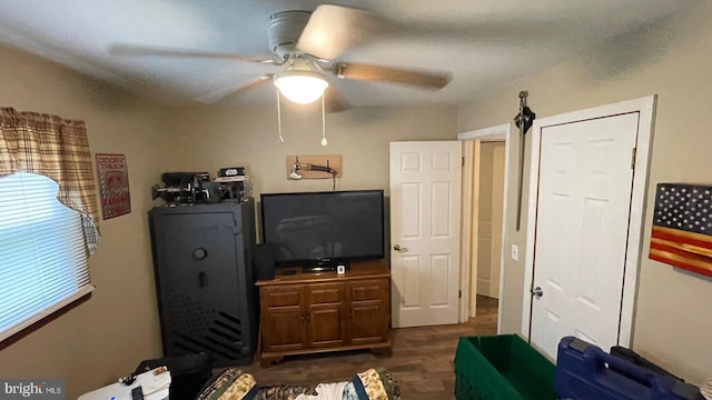 living room featuring ceiling fan and dark hardwood / wood-style flooring