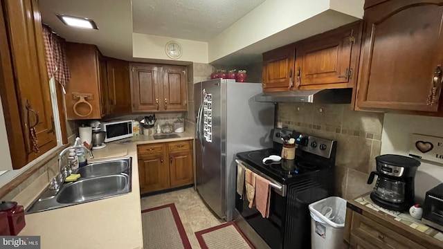 kitchen with decorative backsplash, stainless steel appliances, sink, and a textured ceiling