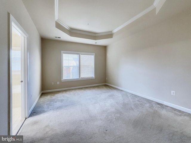 carpeted empty room with crown molding and a tray ceiling