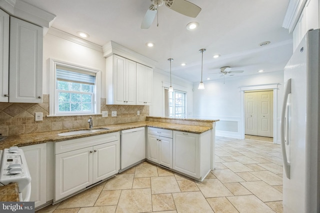 kitchen with white appliances, white cabinetry, kitchen peninsula, and decorative backsplash