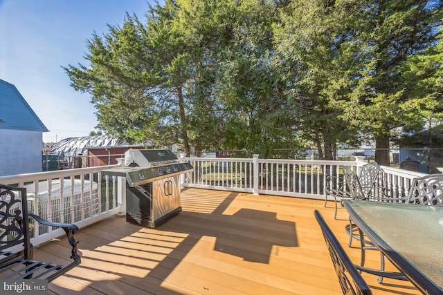 wooden deck featuring a grill