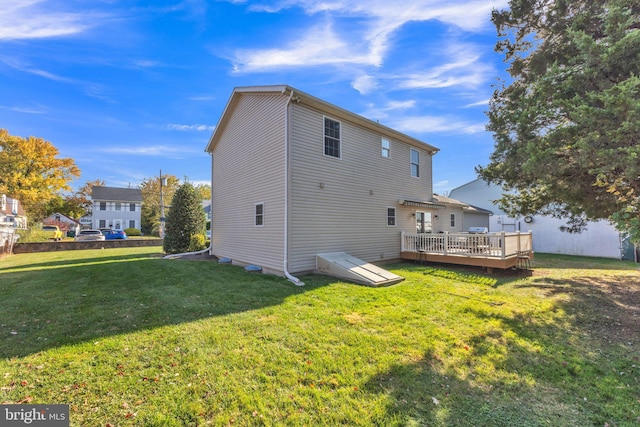 back of property featuring a yard and a wooden deck