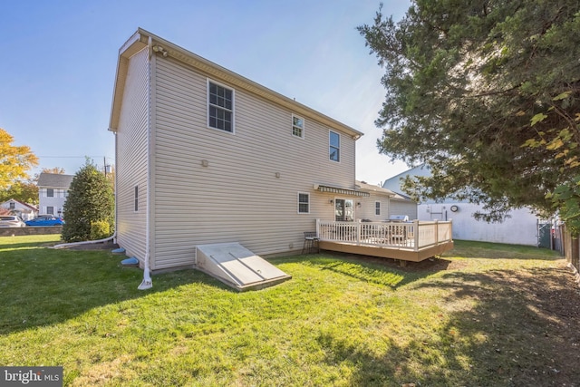 rear view of house featuring a deck and a yard