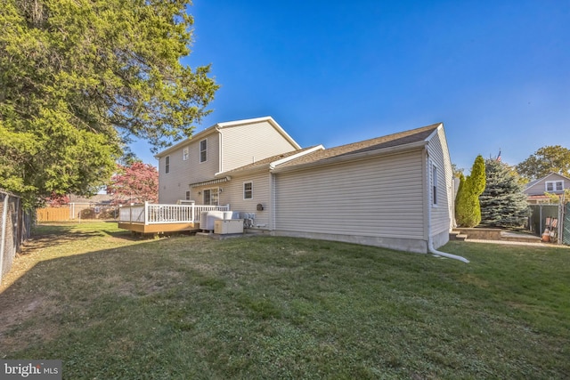 back of house featuring a deck, central AC unit, and a lawn