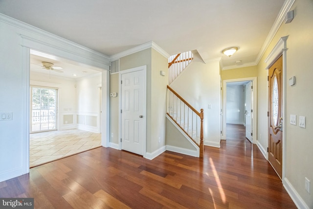 foyer entrance with ceiling fan, ornamental molding, and dark hardwood / wood-style floors