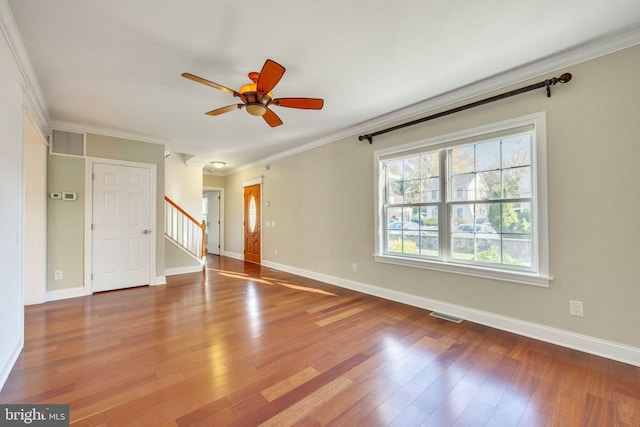 empty room featuring crown molding, wood-type flooring, and ceiling fan