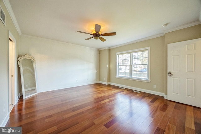 empty room featuring ceiling fan, ornamental molding, and dark hardwood / wood-style flooring