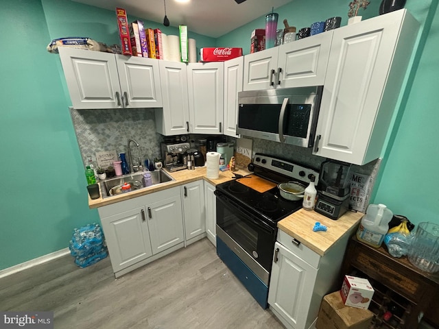 kitchen featuring light hardwood / wood-style floors, black electric range oven, sink, and white cabinets