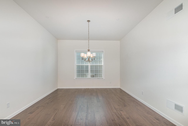 unfurnished dining area featuring an inviting chandelier and dark hardwood / wood-style flooring