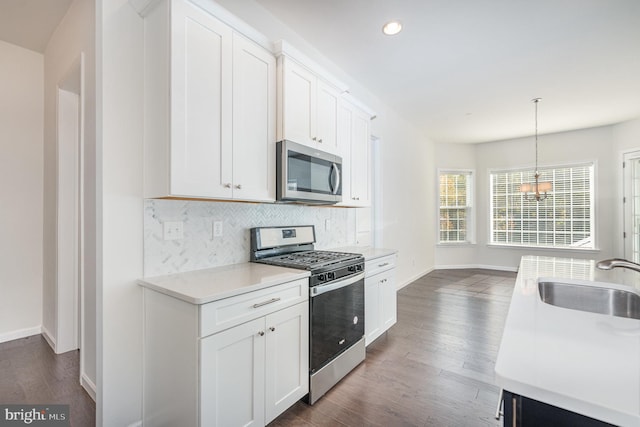 kitchen with white cabinetry, appliances with stainless steel finishes, sink, and dark wood-type flooring