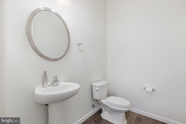 bathroom featuring toilet and wood-type flooring