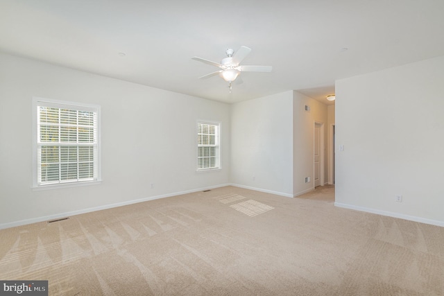 unfurnished room with light carpet, plenty of natural light, and ceiling fan