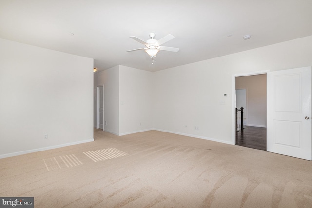 carpeted spare room featuring ceiling fan